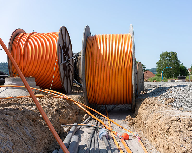 Mehrere Rollen mit Speedpipes auf einer Baustelle zum Verlegen von Glasfaserleitungen